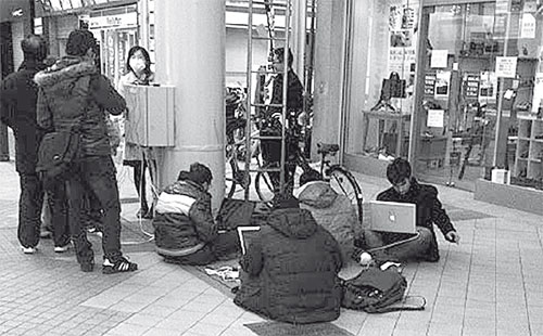 Batteries are charged from a junction in a shopping area (March 13, 2011 in Sendai)